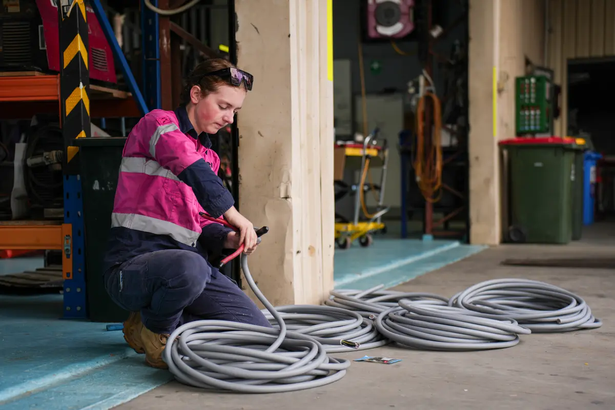 An ACES apprentice preparing electrical conduit in the workshop