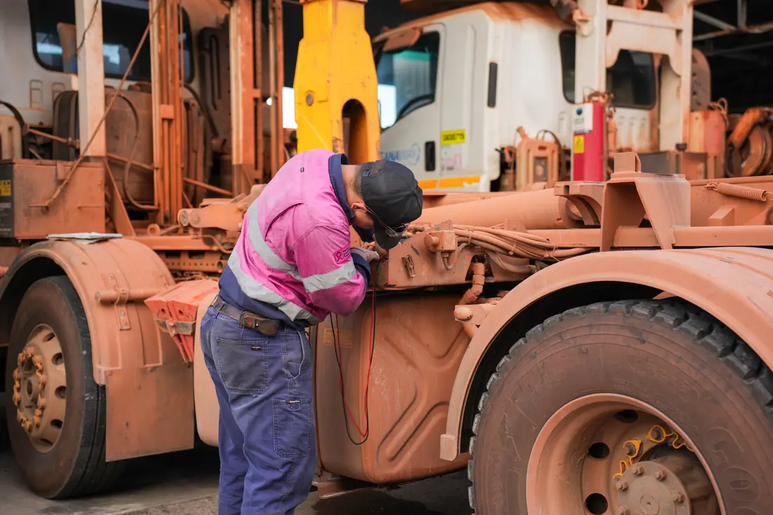 ACES technician servicing heavy equipment in the field